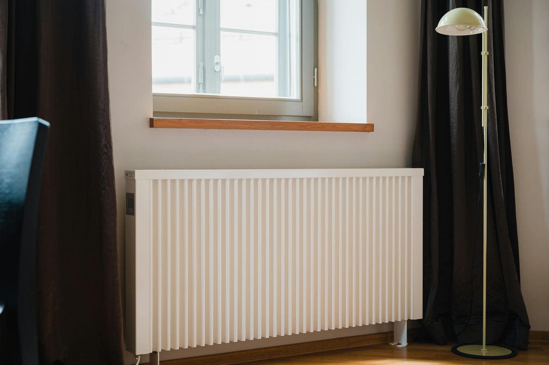 Heller Heizkörper unter einem Fenster in einer Wohnung